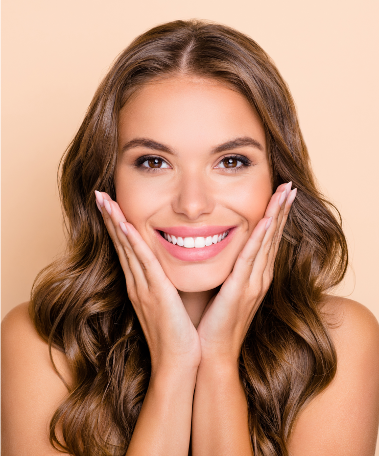 Young woman smiling confidently with hands on chin after a cosmetic dental smile makeover