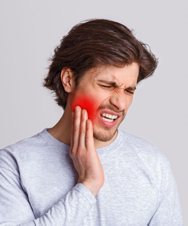 Man holding his jaw in discomfort, showing signs of TMJ disorder or jaw pain